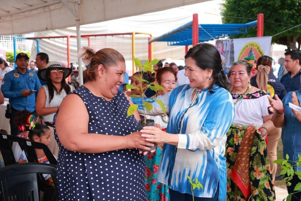 La presidenta municipal de Centro, Yolanda Osuna Huerta, entrega un árbol de macuilís a una vecina durante la jornada del programa Centro +Cerca en la colonia Municipal.