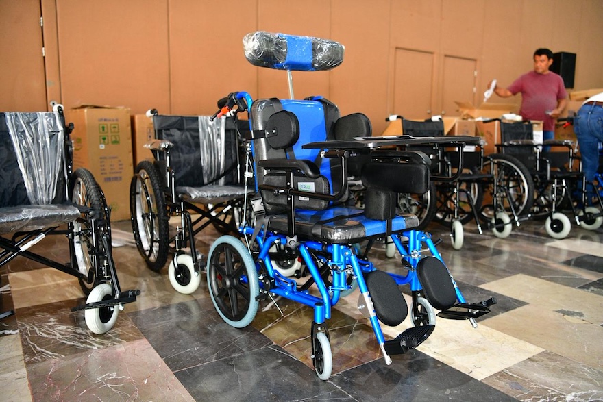 Sillas de ruedas y una silla especial azul alineadas para entrega en Tabasco.
