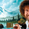 Bob Ross pintando un paisaje con "árboles felices" durante su programa, antes de la subasta de sus cuadros originales.