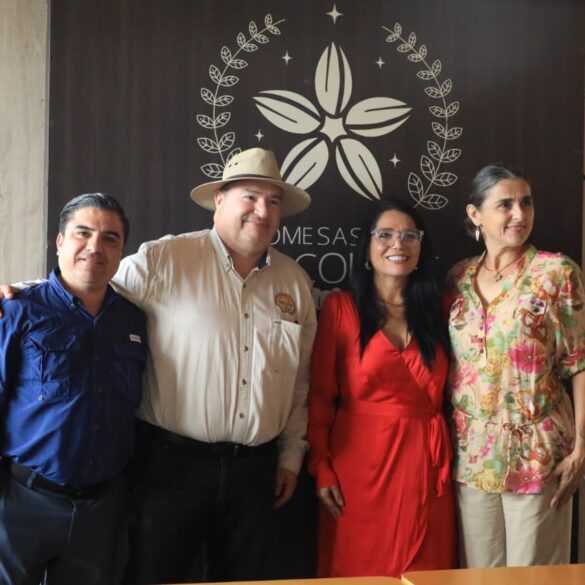 Grupo de cuatro personas posa sonriente frente al logotipo del evento chocolatero.