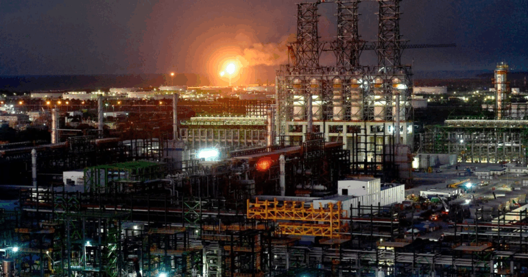Vista aérea de la refinería de Dos Bocas al amanecer, con instalaciones industriales iluminadas.