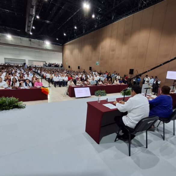 Personas participantes en el foro se saludan y dialogan en un ambiente cordial dentro del recinto.