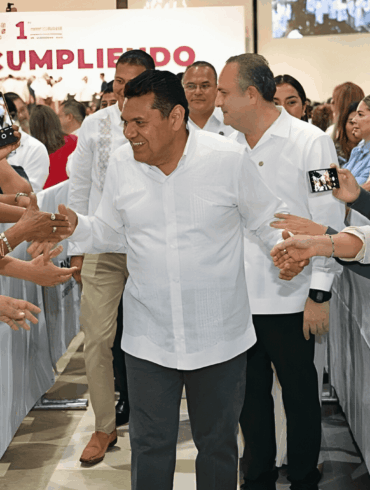 Javier May saluda a ciudadanas y ciudadanos mientras avanza por el pasillo del Centro de Convenciones, rodeado de teléfonos y manos extendidas.