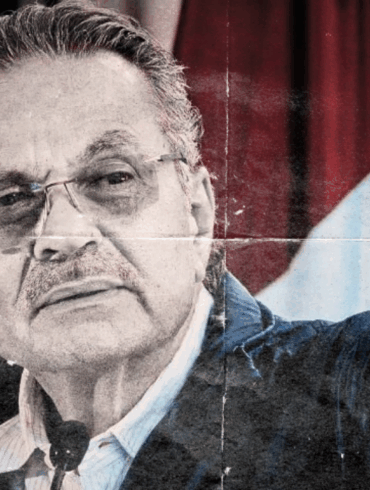Retrato de Octavio Romero Oropeza en acto público, rostro serio, fondo institucional difuso.