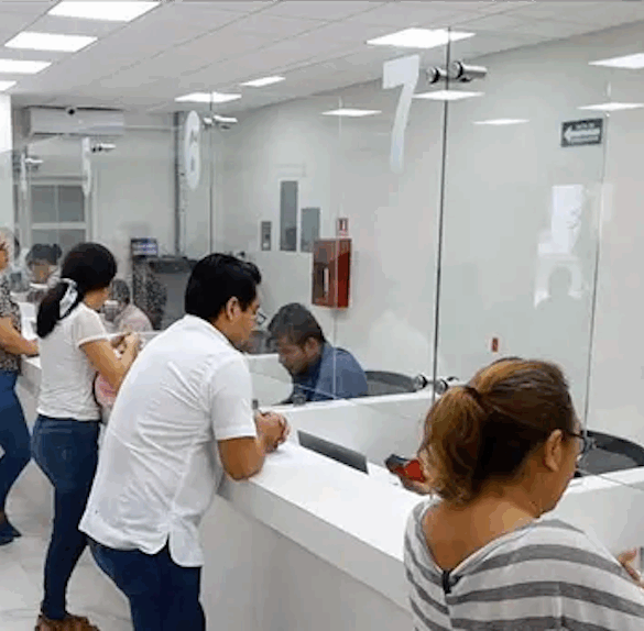 Ciudadanos realizando pago de predial en ventanilla municipal durante jornada de descuentos.