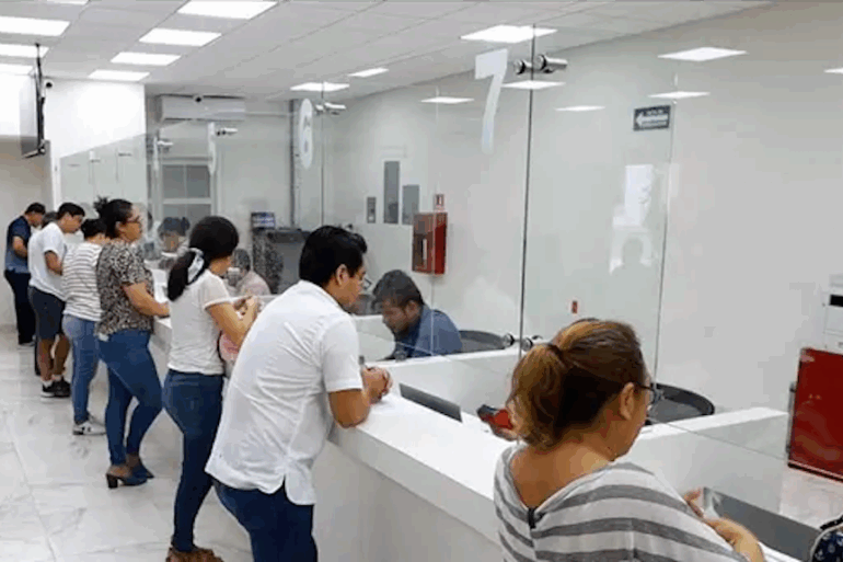 Ciudadanos realizando pago de predial en ventanilla municipal durante jornada de descuentos.