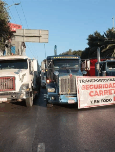 Bloqueo carretero de transportistas y agricultores en una autopista federal, con vehículos detenidos y presencia de manifestantes.