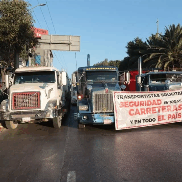 Bloqueo carretero de transportistas y agricultores en una autopista federal, con vehículos detenidos y presencia de manifestantes.