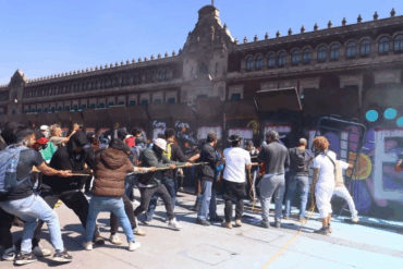 Manifestantes de la Generación Z intentando derribar vallas en el Zócalo de la Ciudad de México
