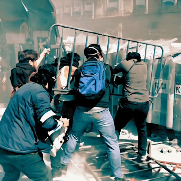Jóvenes empujan una valla metálica contra el muro policial durante un choque en el Zócalo.
