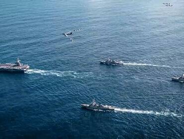 Buques militares navegan en formación escoltando una embarcación en aguas del Caribe durante un operativo marítimo.