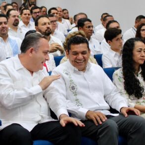 El gobernador Javier May Rodríguez conversa y ríe con el presidente del Tribunal Superior de Justicia, Carlos Efraín Reséndez Bocanegra, durante el Informe Anual de Labores 2025, acompañados por funcionarios y asistentes en el auditorio del TSJ.