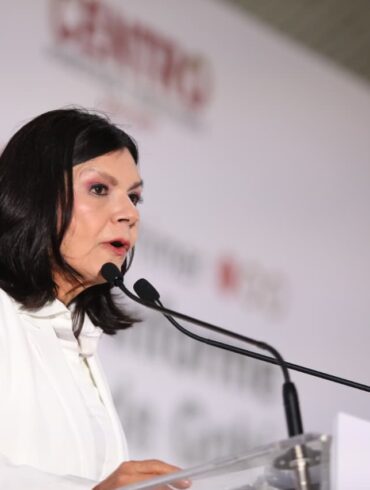 Retrato de Yolanda Osuna hablando en el podio durante su Primer Informe de Gobierno, con gesto firme y fondo institucional desenfocado.