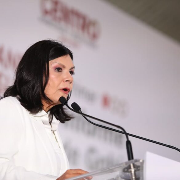 Retrato de Yolanda Osuna hablando en el podio durante su Primer Informe de Gobierno, con gesto firme y fondo institucional desenfocado.