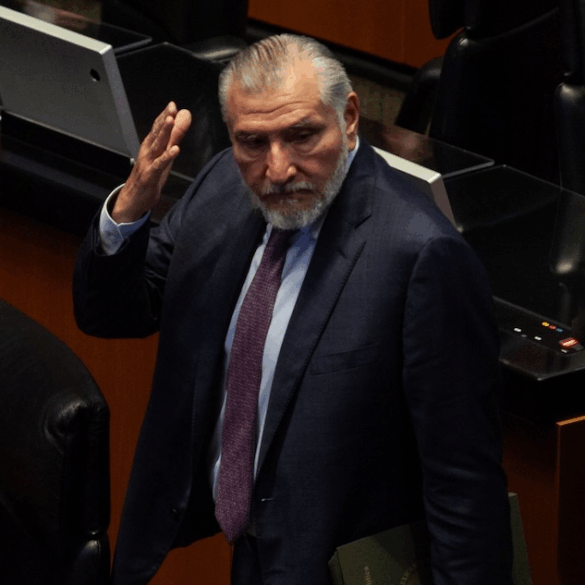 Legislador de traje oscuro gesticula durante una sesión en el pleno del Senado, rodeado de curules y asistentes.