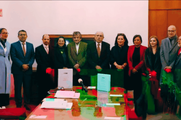 Consejeros del INE y el titular de la comisión presidencial para la reforma electoral, Pablo Gómez, posan junto a documentos del proyecto durante una reunión en Palacio Nacional.