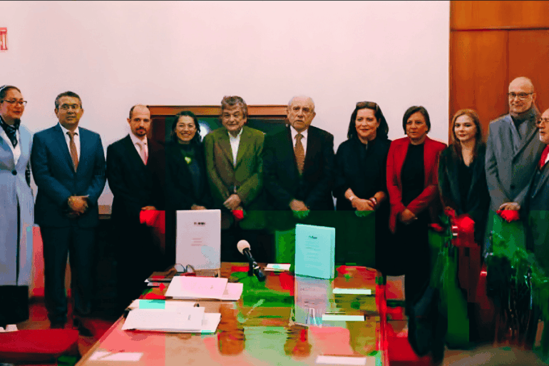 Consejeros del INE y el titular de la comisión presidencial para la reforma electoral, Pablo Gómez, posan junto a documentos del proyecto durante una reunión en Palacio Nacional.