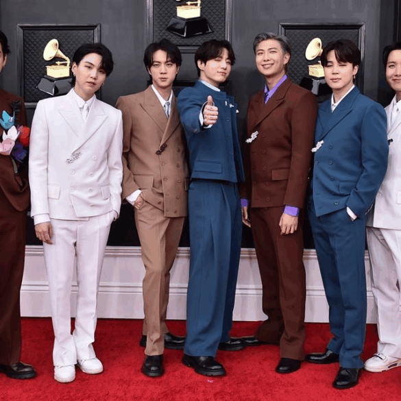 Integrantes de BTS posan en alfombra roja con trajes formales durante una premiación internacional