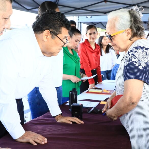 Gobernador Javier May Rodríguez escucha personalmente a una adulta mayor durante una jornada de atención ciudadana en Macuspana, acompañado de su equipo de trabajo.