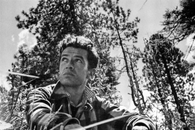 Escritor mexicano sentado en el campo, rodeado de árboles, observa el paisaje en blanco y negro.