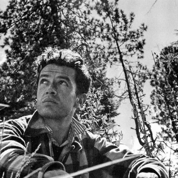 Escritor mexicano sentado en el campo, rodeado de árboles, observa el paisaje en blanco y negro.