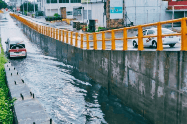 Taxi circula parcialmente bajo el agua en el paso a desnivel del Distribuidor Vial Universidad en Villahermosa, tras intensas lluvias del frente frío 27.