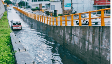 Taxi circula parcialmente bajo el agua en el paso a desnivel del Distribuidor Vial Universidad en Villahermosa, tras intensas lluvias del frente frío 27.