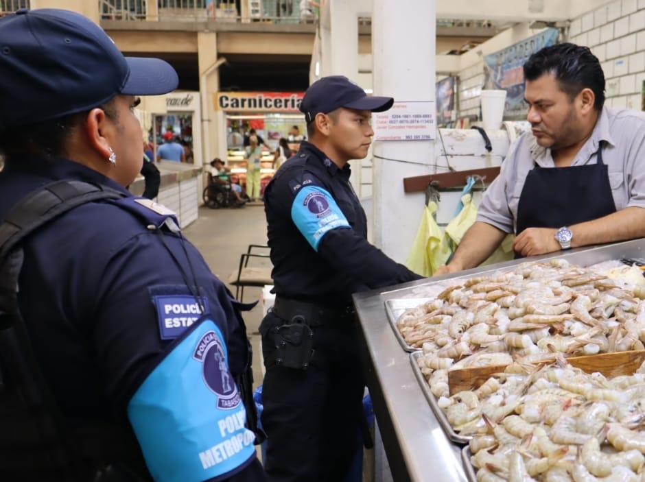 Elementos de la Policía Metropolitana dialogan con un comerciante de mariscos al interior del mercado, durante un recorrido de proximidad y vigilancia en zonas de alta actividad comercial.