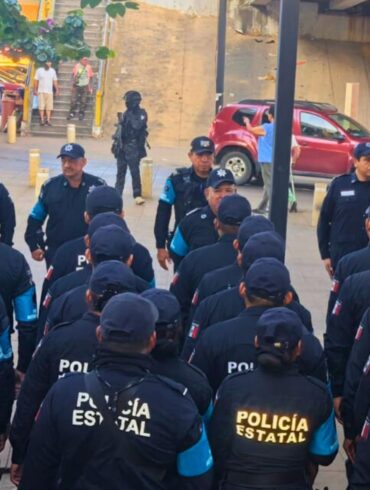 Oficiales de la Policía Estatal y Metropolitana reciben instrucciones operativas durante un despliegue de seguridad en zona urbana, bajo un paso elevado.