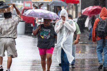 Vehículo circula bajo intensa lluvia en una avenida de Villahermosa durante el aviso por lluvias torrenciales emitido por autoridades de Protección Civil.