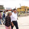 El gobernador Javier May Rodríguez camina junto a una vecina durante la supervisión de obras de equipamiento urbano en Cunduacán, mientras personal técnico y habitantes acompañan el recorrido en zona intervenida.