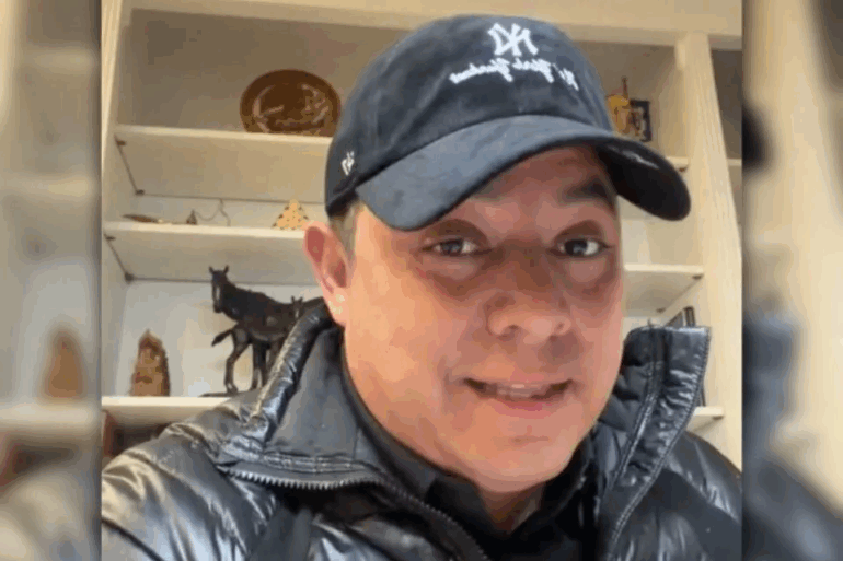 Un hombre con gorra y chamarra acolchada graba un mensaje en video desde una oficina con estantes al fondo, relacionado con el anuncio del veto a la reforma electoral en San Luis Potosí.