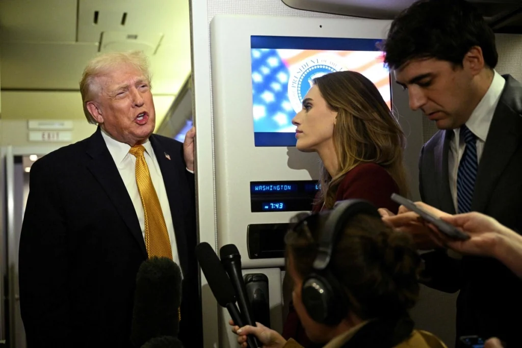 Donald Trump habla con reporteros a bordo del avión presidencial durante un vuelo oficial