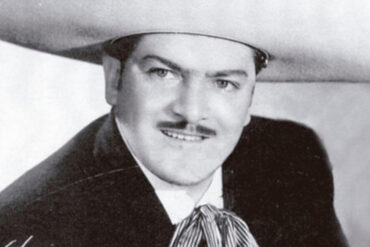 José Alfredo Jiménez durante una presentación pública acompañado por mariachi tradicional mexicano.