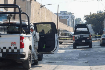 Patrullas de la Policía Municipal acordonan una calle con cinta amarilla mientras agentes inspeccionan una escena de violencia urbana en zona habitacional.