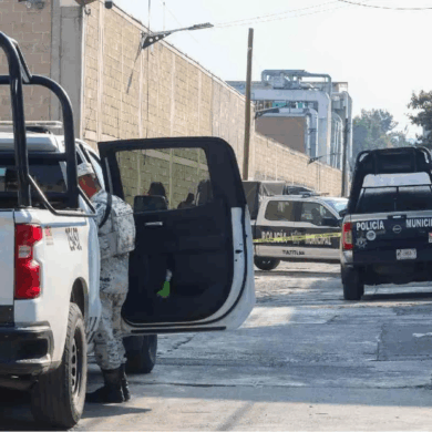 Patrullas de la Policía Municipal acordonan una calle con cinta amarilla mientras agentes inspeccionan una escena de violencia urbana en zona habitacional.