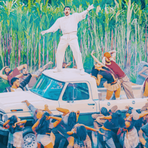 Bad Bunny entra entre cañaverales con balón; equipo de TV graba la escena.