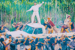 Bad Bunny entra entre cañaverales con balón; equipo de TV graba la escena.