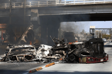 Vehículos incendiados bajo un puente en Jalisco durante narcobloqueos tras la muerte de El Mencho