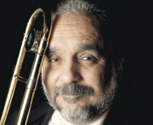 Willie Colón posando con su trombón en retrato formal en Nueva York
