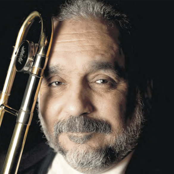 Willie Colón posando con su trombón en retrato formal en Nueva York