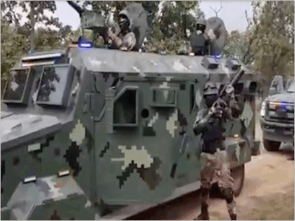 Elementos armados encapuchados sobre y junto a un vehículo blindado con camuflaje digital durante un operativo en zona rural del occidente de México.