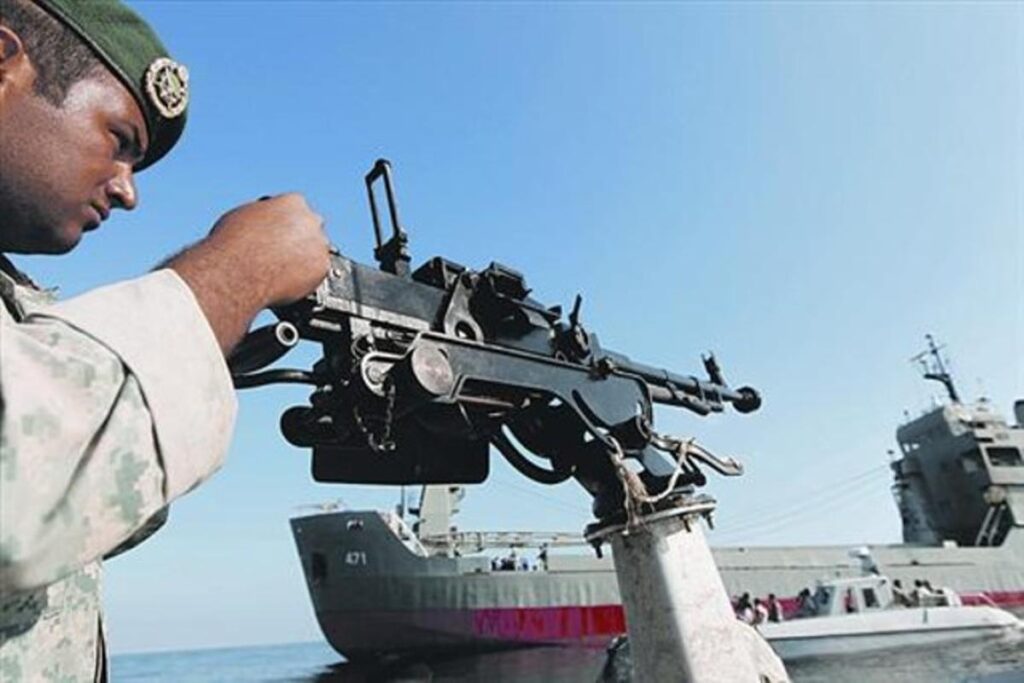 Soldado armado vigila un buque petrolero en el estrecho de Ormuz durante tensiones militares en el Golfo Pérsico.