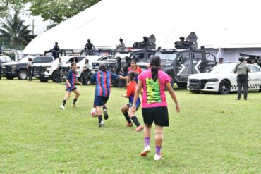 Niñas juegan fútbol frente a unidades de seguridad durante Jornadas de Paz en Tabasco