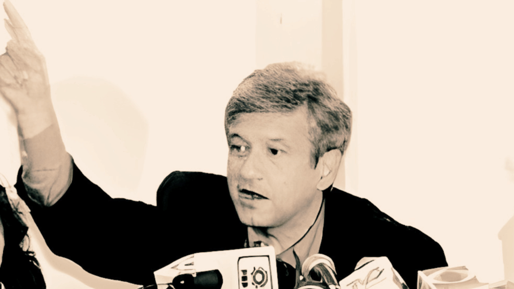 Andrés Manuel López Obrador en conferencia de prensa, señalando con la mano derecha mientras habla ante varios micrófonos, durante su denuncia del gasto proselitista de Roberto Madrazo Pintado en Tabasco.