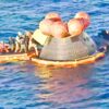 La cápsula Orión de la misión Artemis II flotando en el océano Pacífico rodeada de botes y personal de rescate tras el amerizaje frente a San Diego