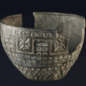 Copa de Berlanga, cuenco romano de bronce fragmentado con decoración esmaltada geométrica, fotografiada sobre fondo negro