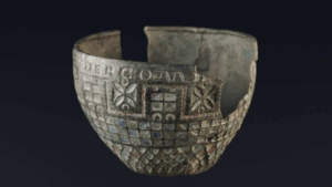 Copa de Berlanga, cuenco romano de bronce fragmentado con decoración esmaltada geométrica, fotografiada sobre fondo negro