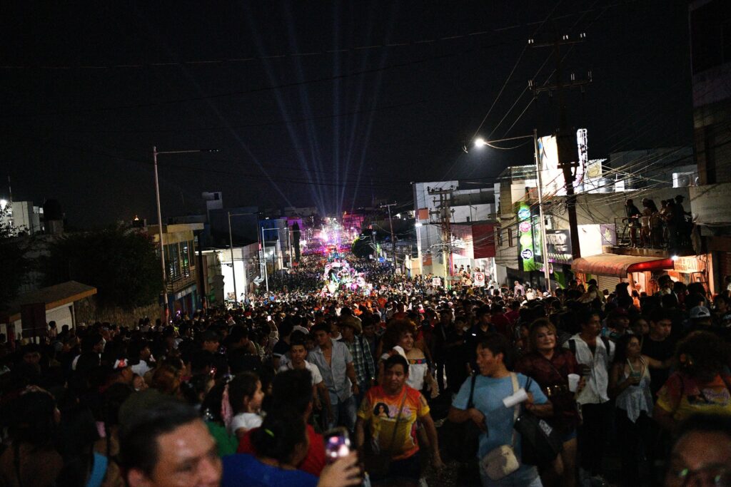 Multitud desbordada en las calles de Villahermosa durante el Desfile de Carros Alegóricos de la Feria Tabasco 2026, con luces de las alegorías al fondo