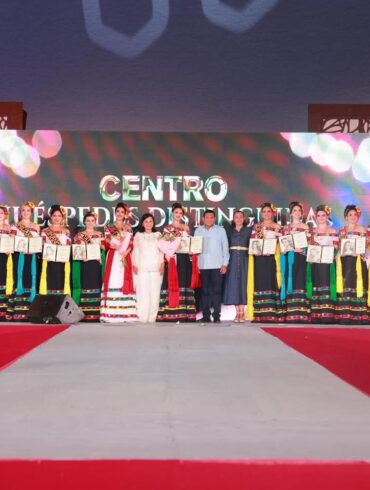Las 17 embajadoras de la Feria Tabasco 2026 posan con sus pergaminos de Huéspedes Distinguidas en el escenario de Plaza de la Revolución, Villahermosa